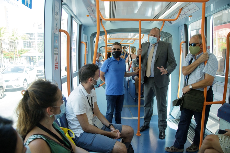El vicepresidente primero del Cabildo de Tenerife, Enrique Arriaga, habla con miembros de la delegación turística en el interior del tranvía.