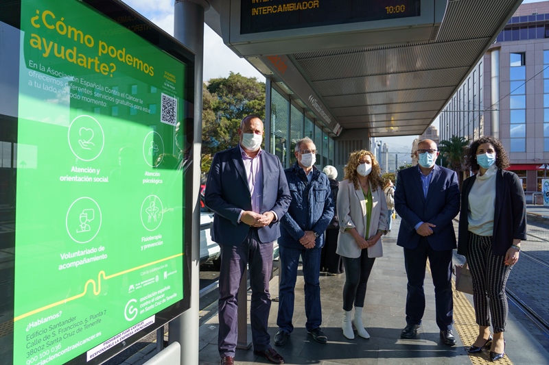 Autoridades del Cabildo y de AECC en la parada Fundación junto al cartel de la campaña.