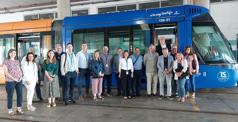 Asistentes a la Comisión de Comunicación de ATUC junto a un tranvía.